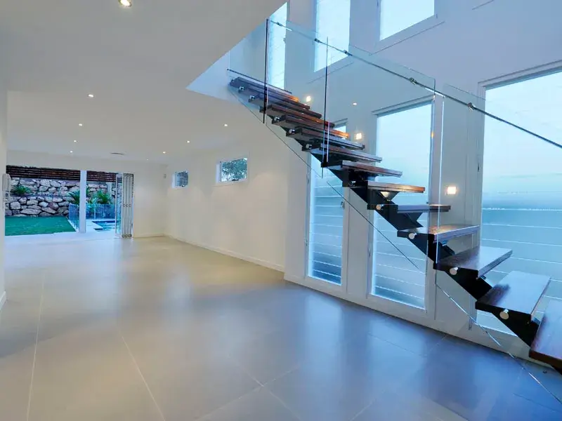 Structural steel design for modern floating stairs and glass balustrade in a Brisbane home.